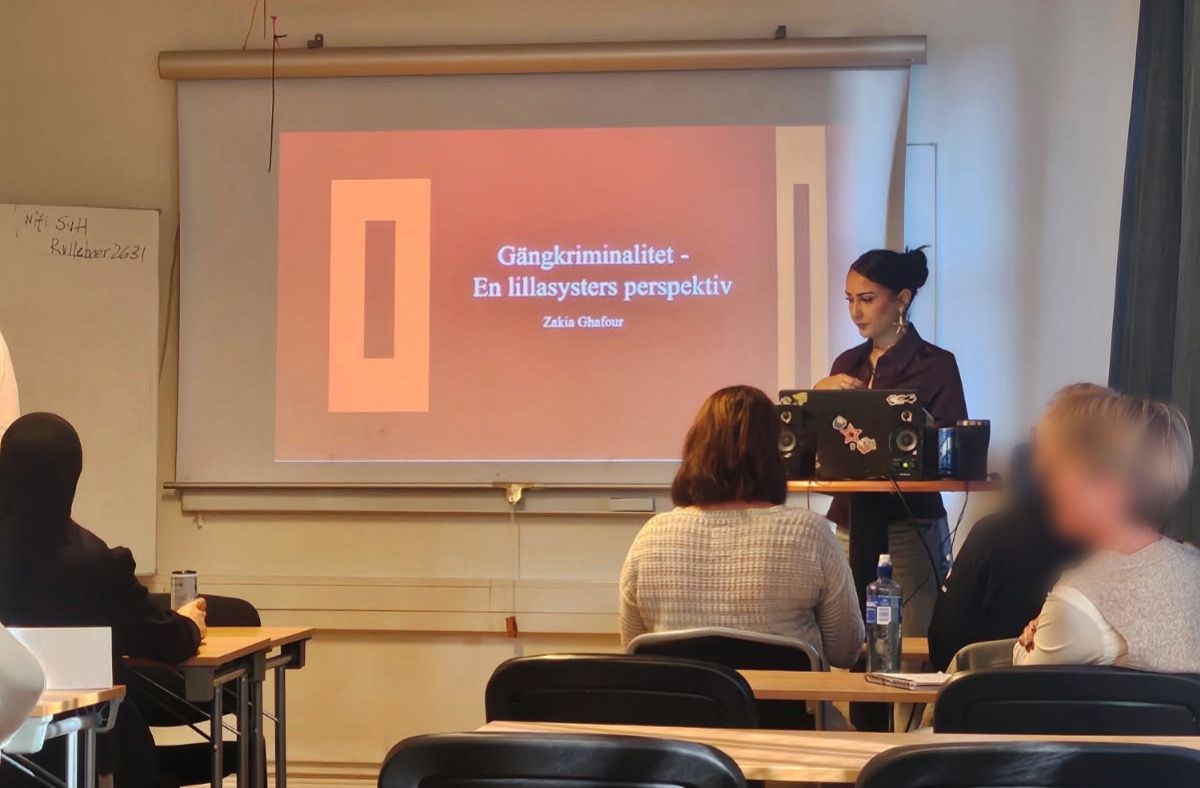 Deltagare lyssnar när Zakia Gafour föreläser om gängkriminalitet i en föreläsningssal.